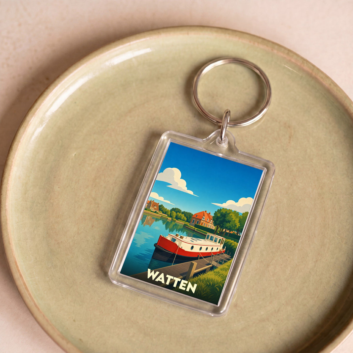 Porte-clés souvenir de la ville de Watten avec une illustration stylisée d'une péniche sur un canal.