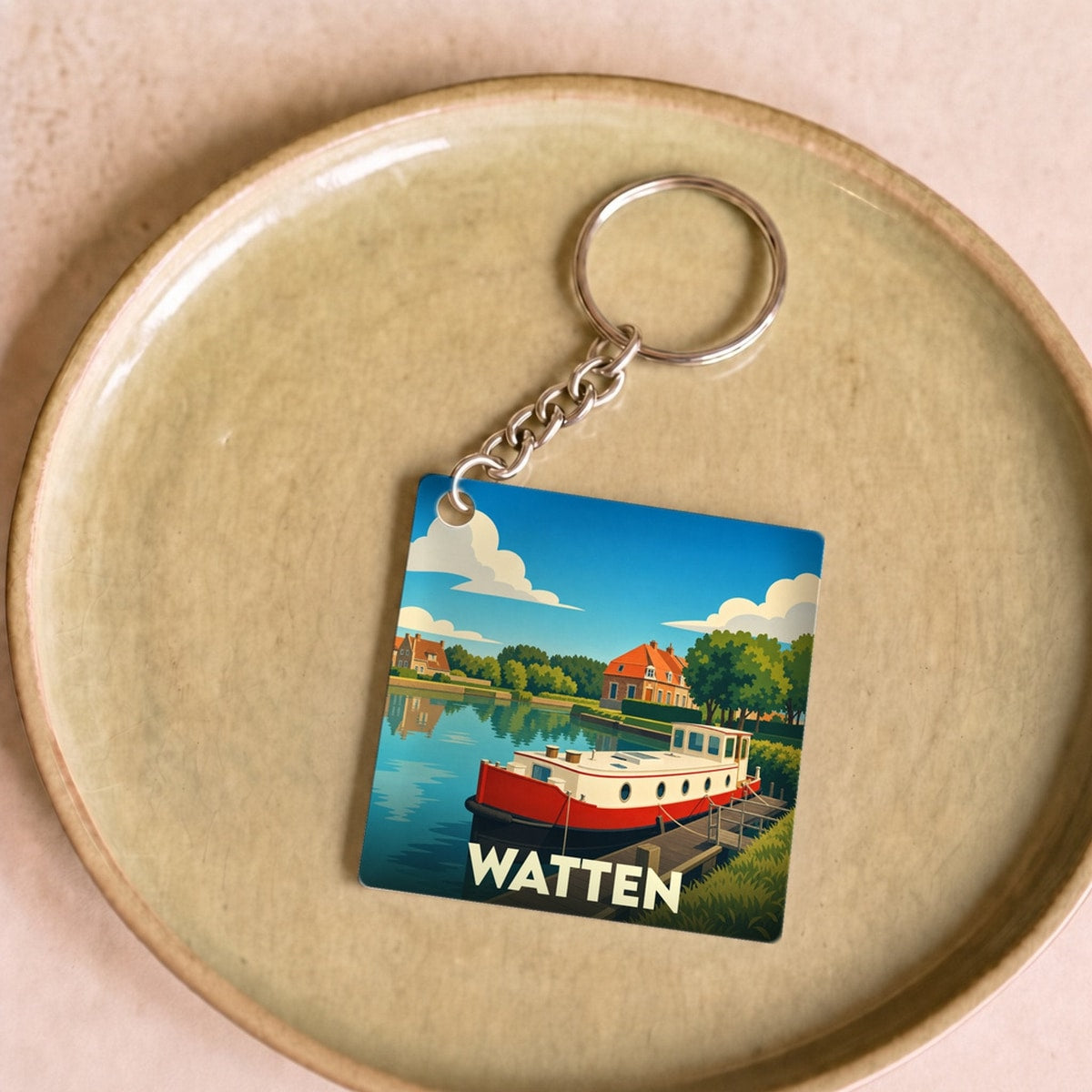 Porte-clés souvenir de la ville de Watten avec une illustration stylisée d'une péniche sur un canal.