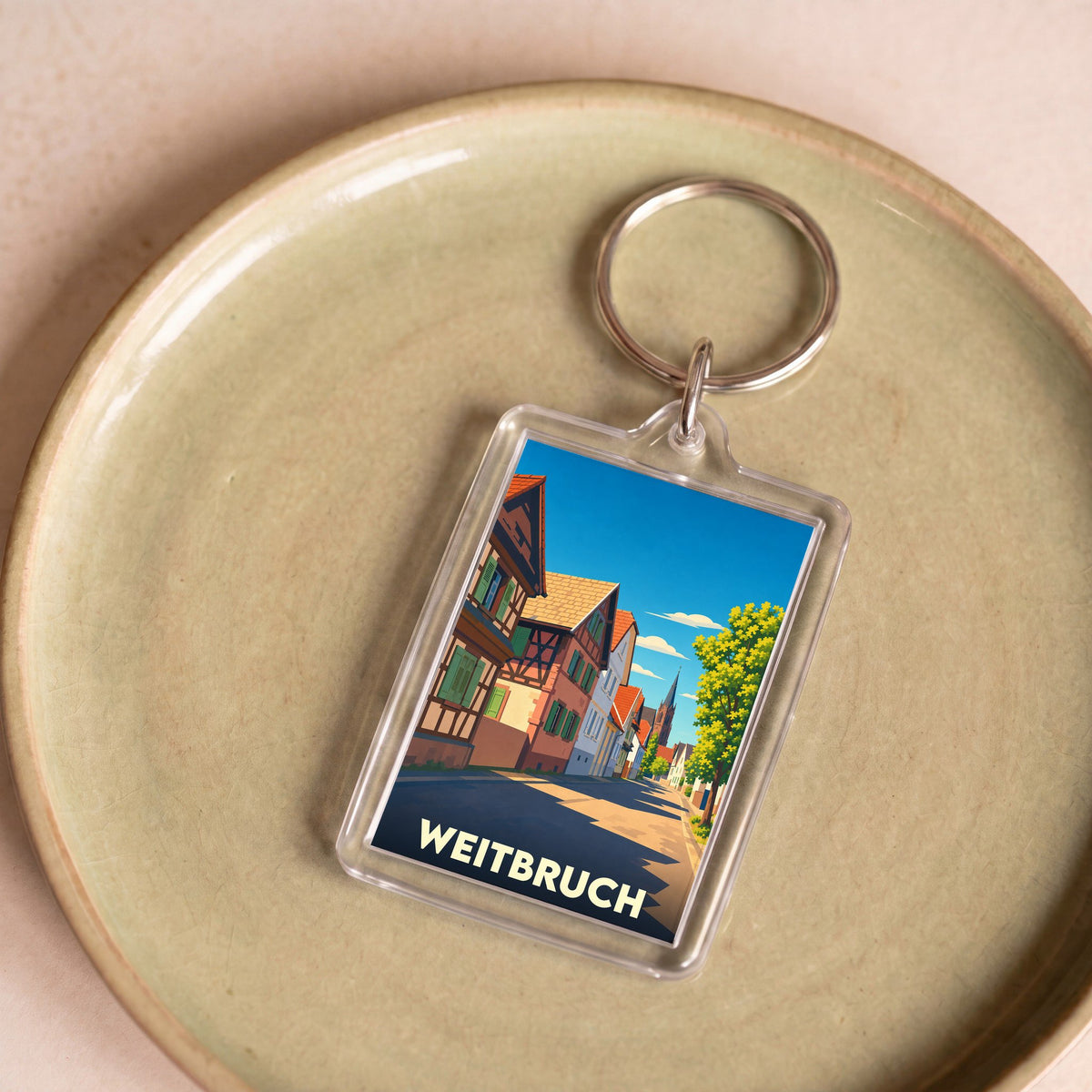 Porte-clés souvenir de la ville de Weitbruch avec une illustration stylisée de ses maisons à colombages.