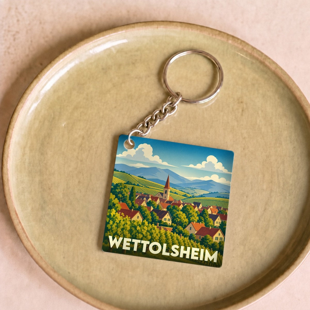Porte-clés souvenir de la ville de Wettolsheim avec une illustration stylisée de son paysage de vignobles.