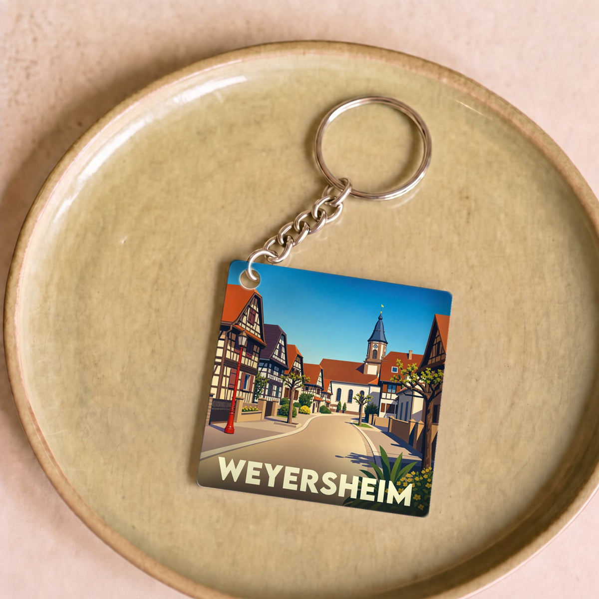 Porte-clés souvenir de la ville de Weyersheim avec une illustration stylisée de ses maisons à colombages.