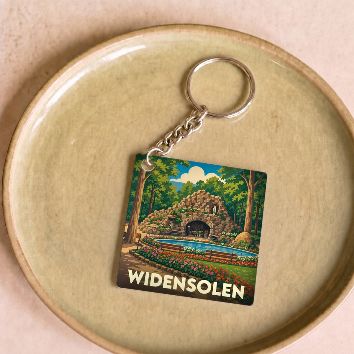 Porte-clés souvenir de la ville de Widensolen avec une illustration stylisée d'une grotte dans un parc arboré.