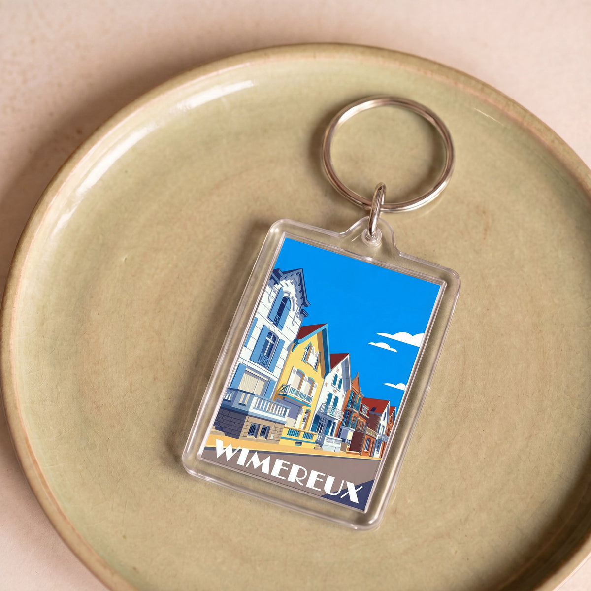 Porte-clés souvenir de la ville de Wimereux avec une illustration stylisée de ses villas colorées.