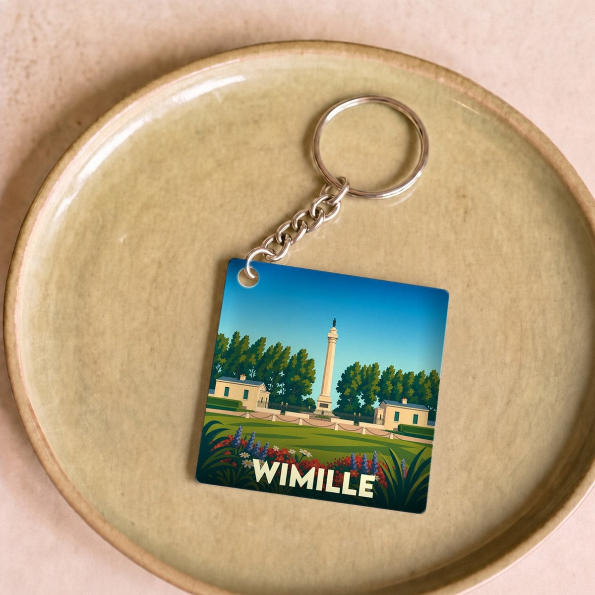 Porte-clés souvenir de la ville de Wimille avec une illustration stylisée de la Colonne de la Grande Armée.