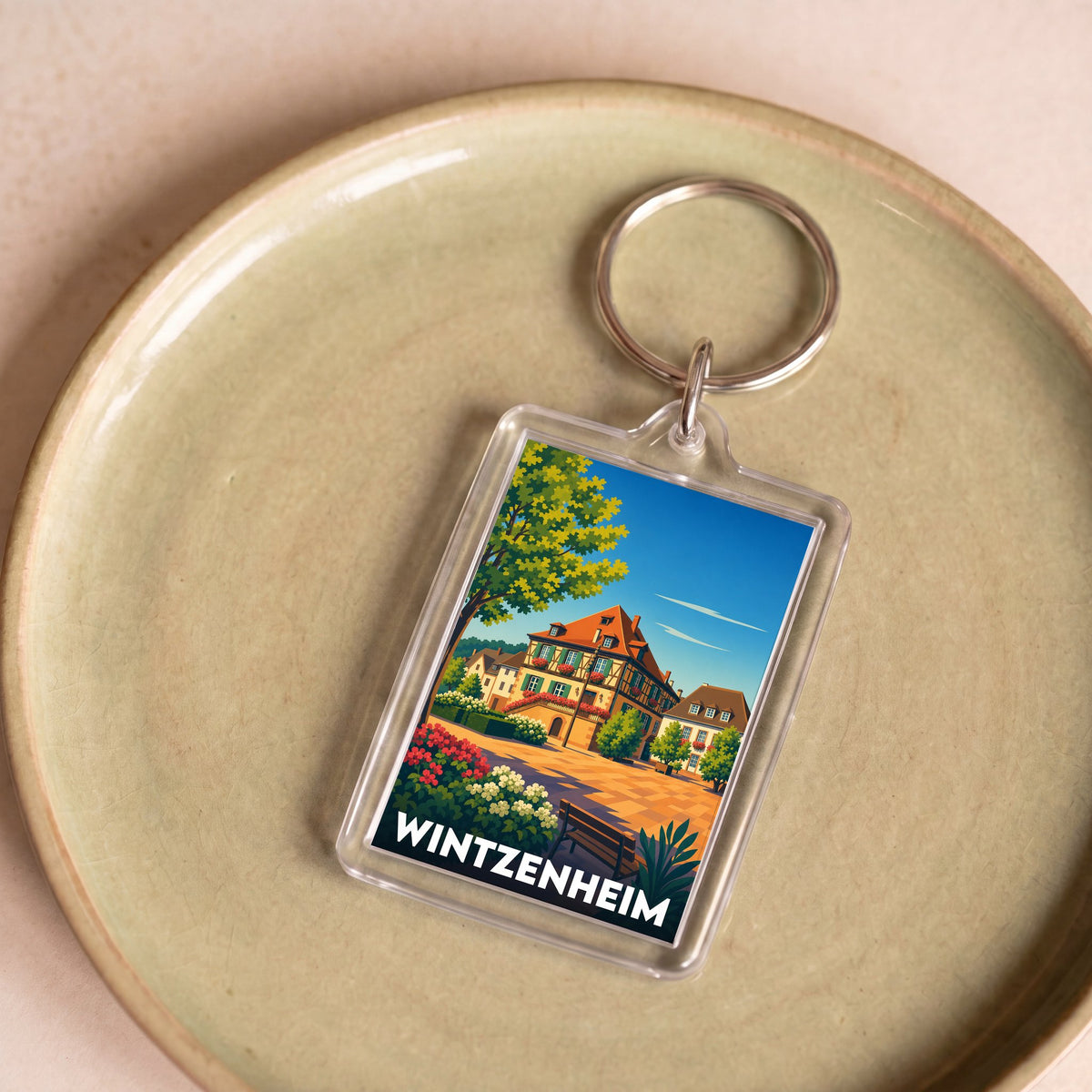 Porte-clés souvenir de la ville de Wintzenheim avec une illustration stylisée de maisons traditionnelles alsaciennes.