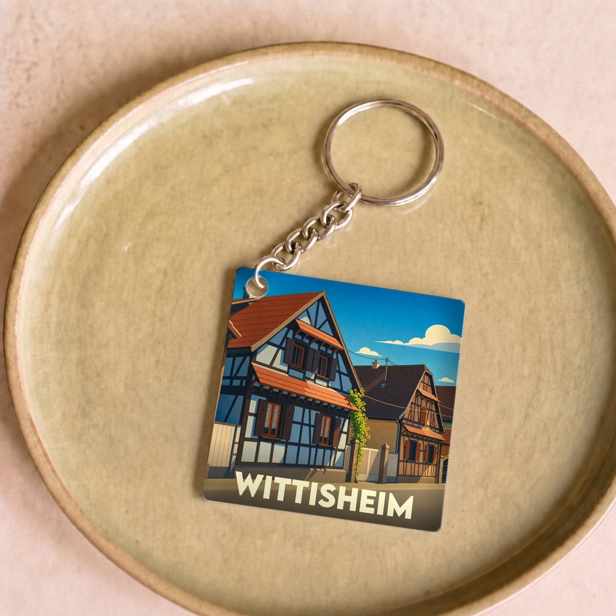 Porte-clés souvenir de la ville de Wittisheim avec une illustration stylisée de maisons à colombages.