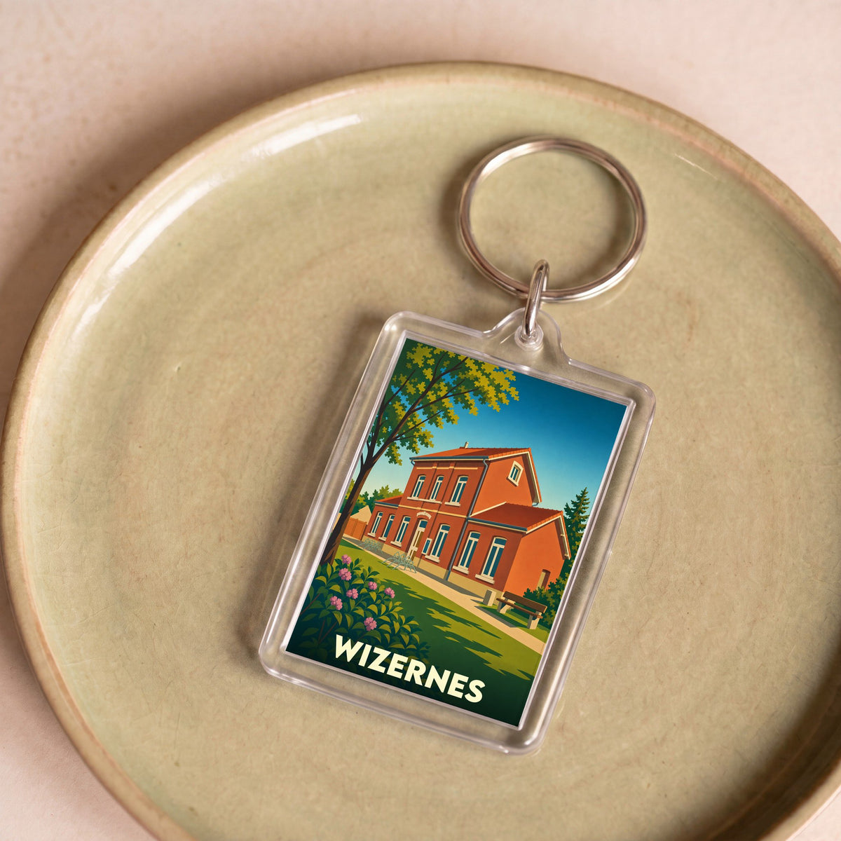 Porte-clés souvenir de la ville de Wizernes avec une illustration stylisée d'un bâtiment en briques rouges.