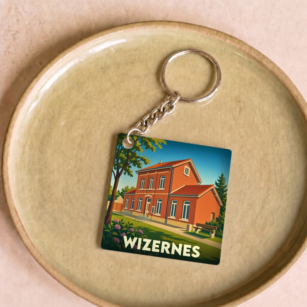 Porte-clés souvenir de la ville de Wizernes avec une illustration stylisée d'un bâtiment en briques rouges.