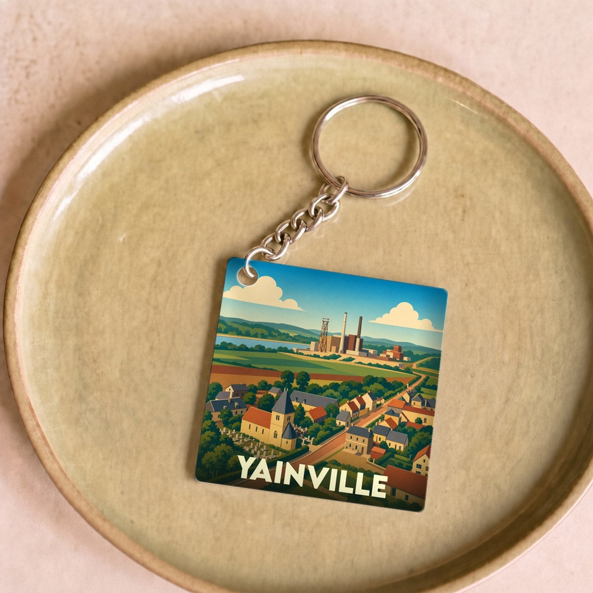 Porte-clés souvenir de la ville de Yainville avec une illustration stylisée.