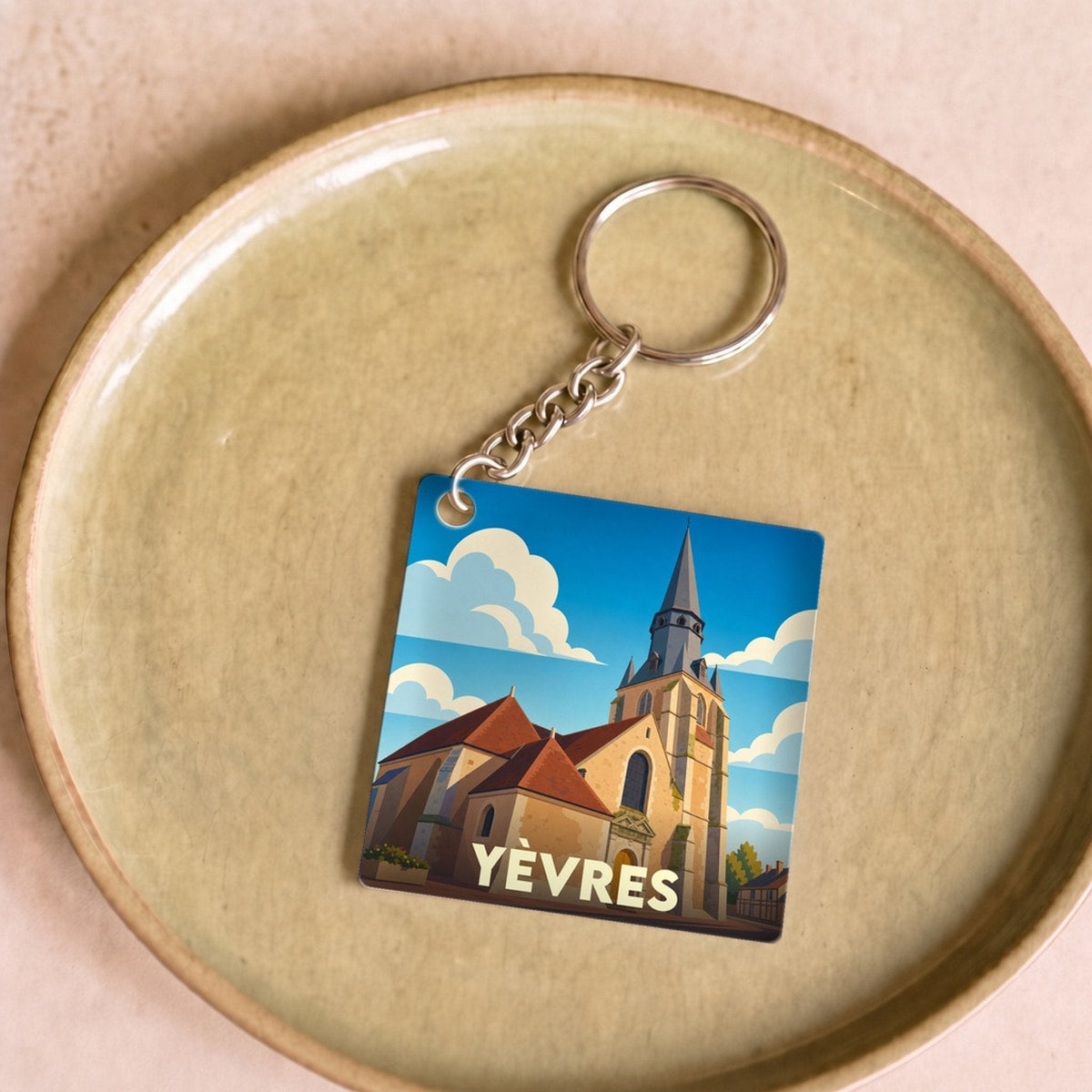 Porte-clés souvenir de la ville de Yèvres avec une illustration stylisée de son église.