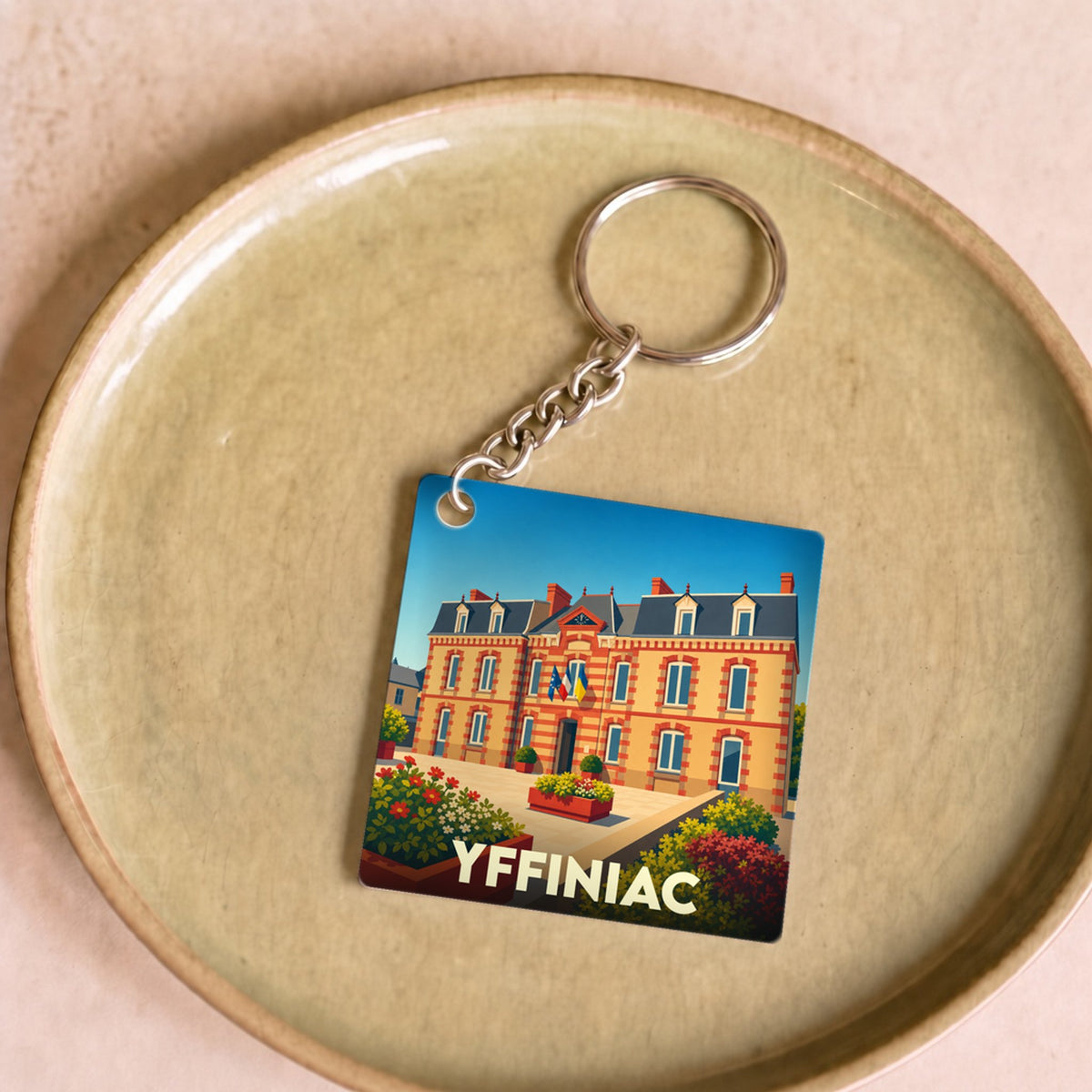 Porte-clés souvenir de la ville d'Yffiniac avec une illustration stylisée de sa mairie.