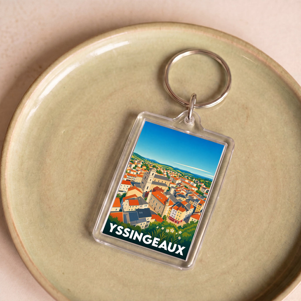 Porte-clés souvenir de la ville d'Yssingeaux avec une illustration stylisée d'un paysage urbain.