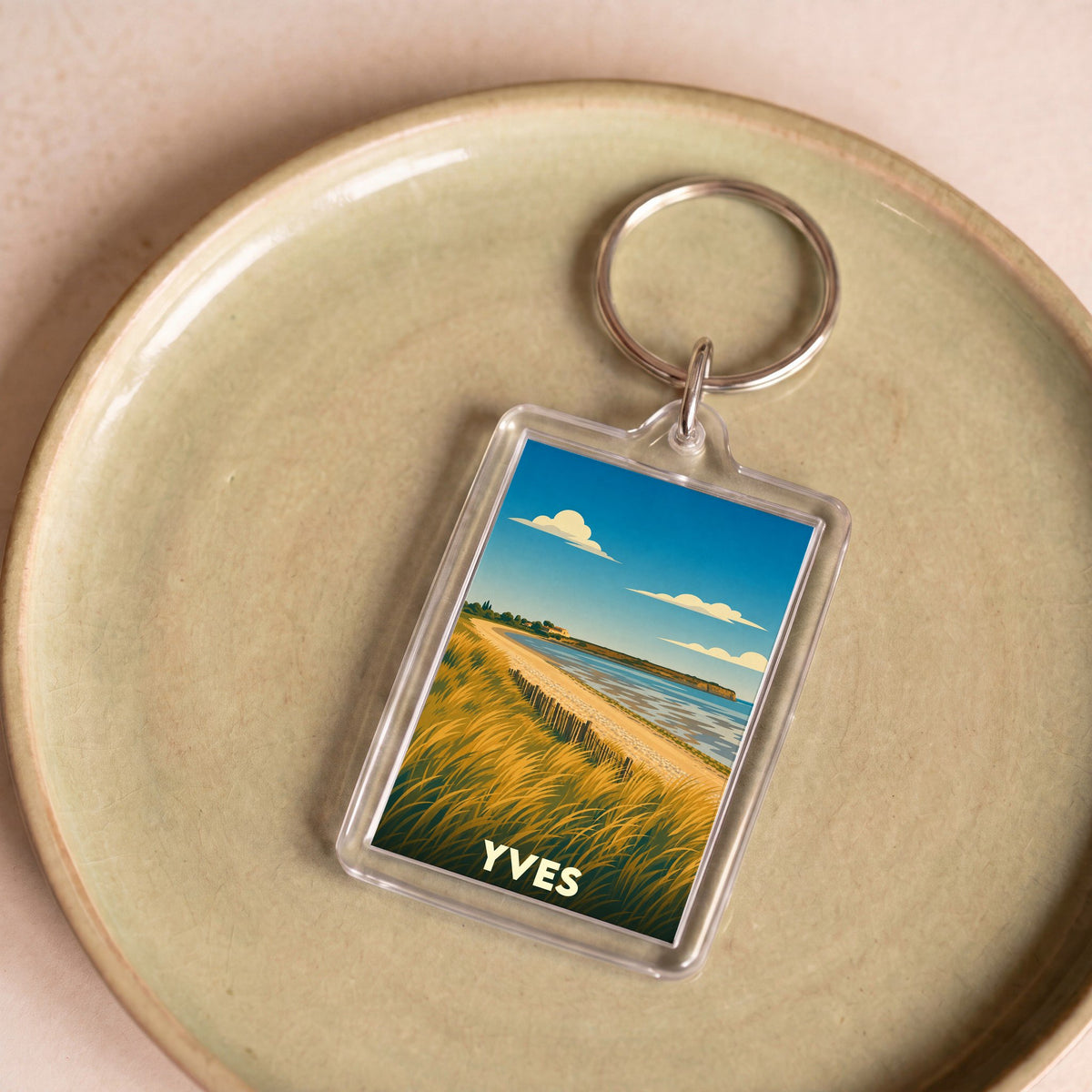 Porte-clés souvenir de la ville de Yves avec une illustration stylisée d'un paysage côtier.