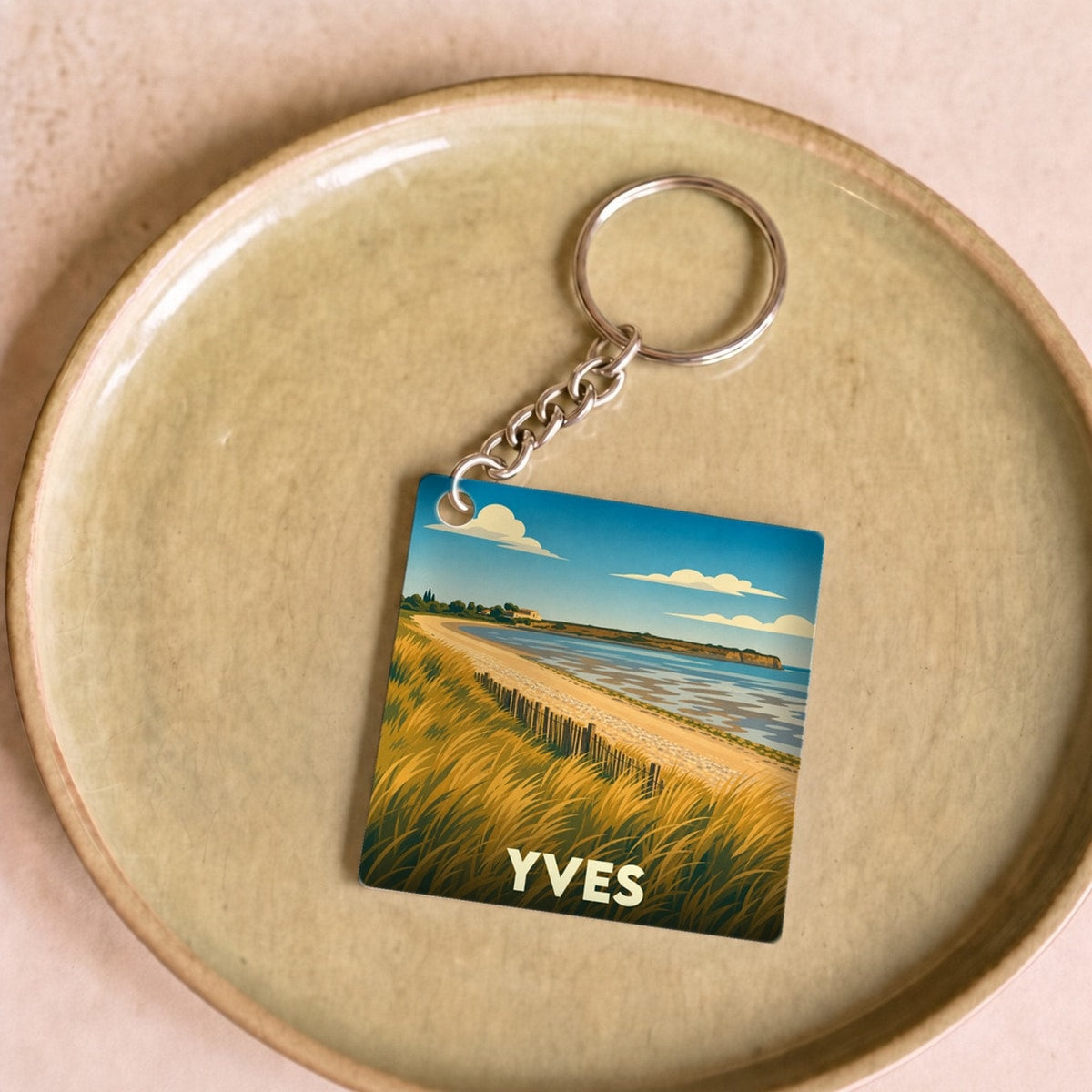 Porte-clés souvenir de la ville de Yves avec une illustration stylisée d'un paysage côtier.
