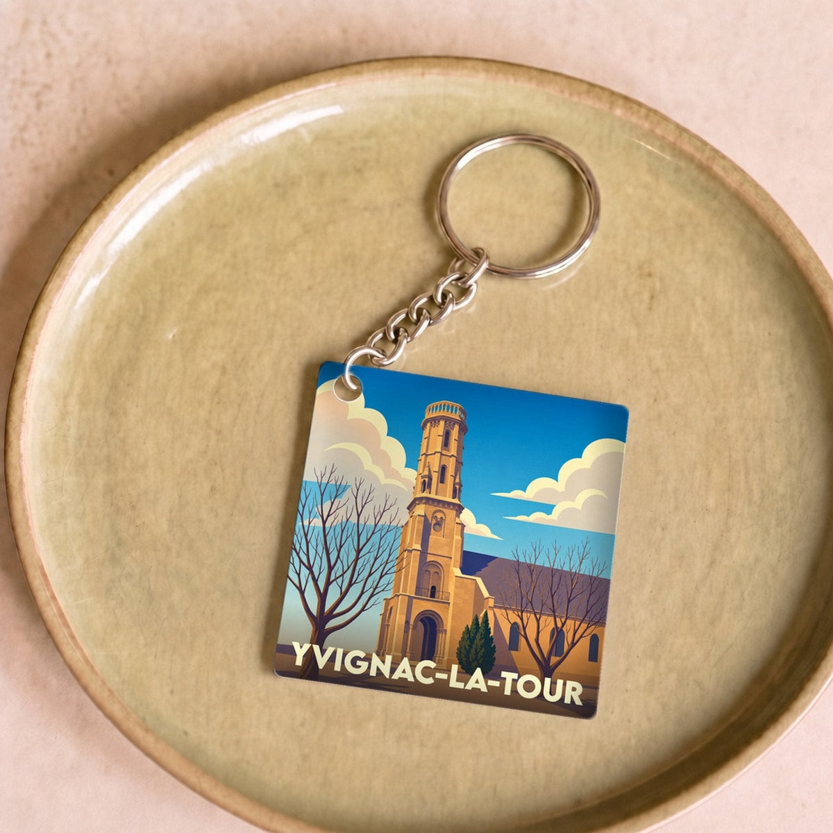 Porte-clés souvenir de la ville d'Yvignac-la-Tour avec une illustration stylisée de son église.