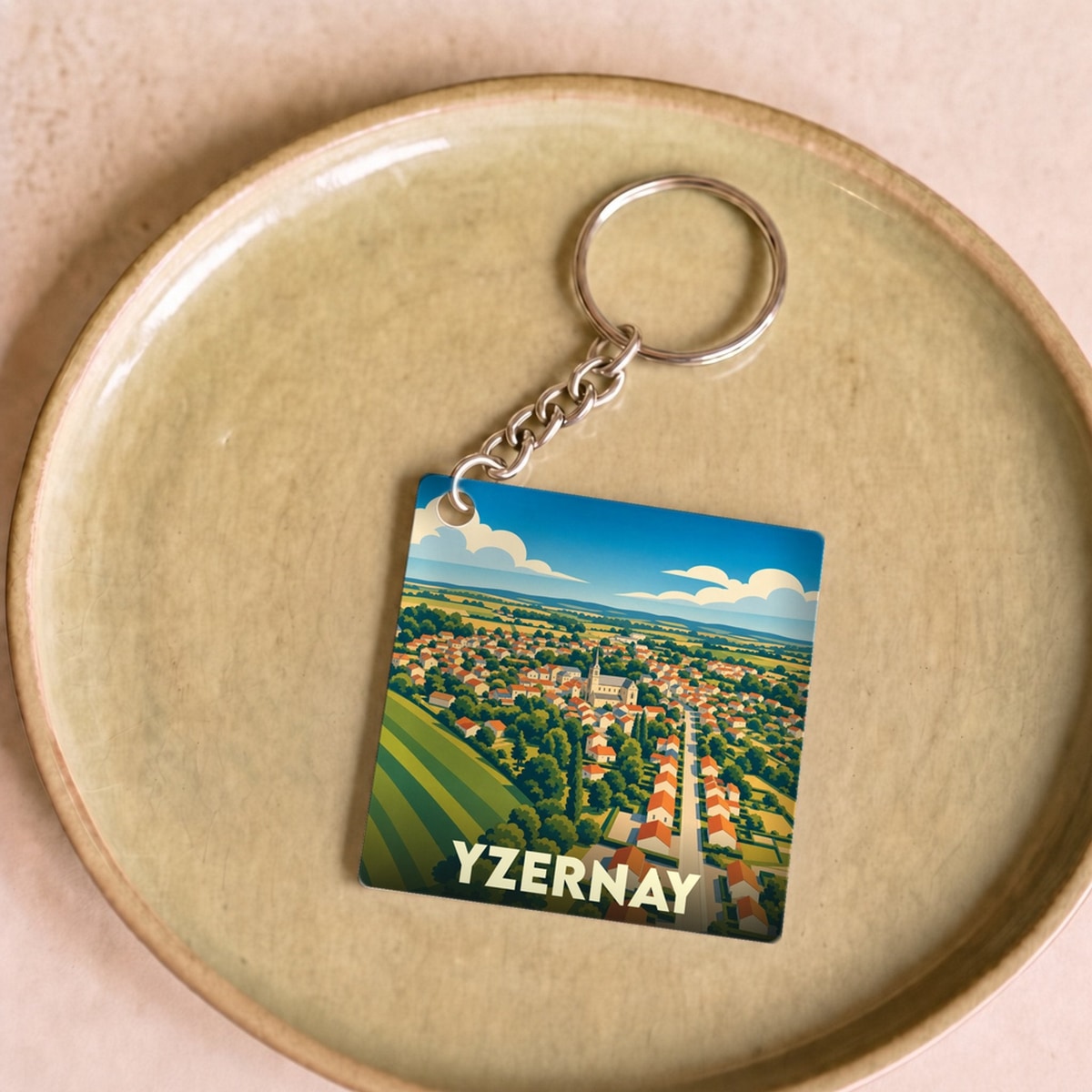 Porte-clés souvenir de la ville d'Yzernay avec une illustration stylisée.