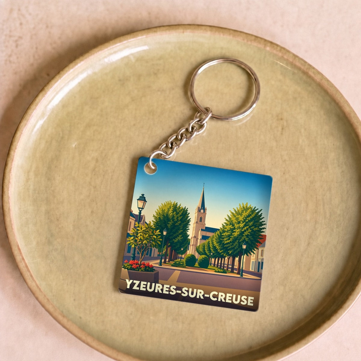 Porte-clés souvenir de la ville de Yzeures-sur-Creuse avec une illustration stylisée.