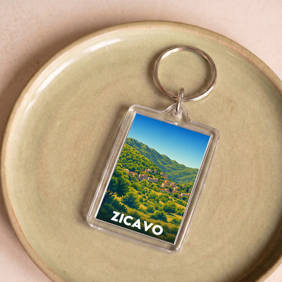 Porte-clés souvenir de la ville de Zicavo avec une illustration de paysage de montagne.