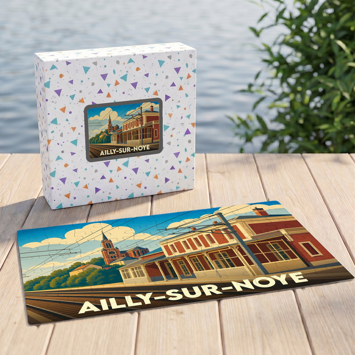 Puzzle souvenir de la ville d'Ailly-sur-Noye avec une illustration stylisée d'une gare et son église.