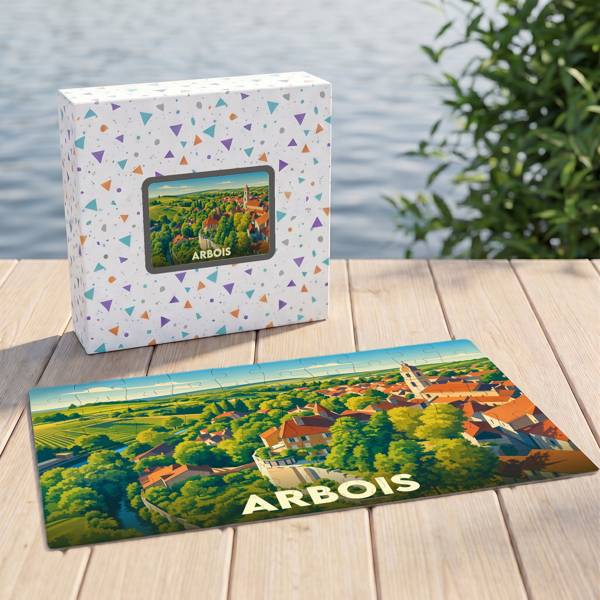 Puzzle souvenir de la ville d'Arbois illustré par une vue panoramique colorée de la cité et de ses vignobles.