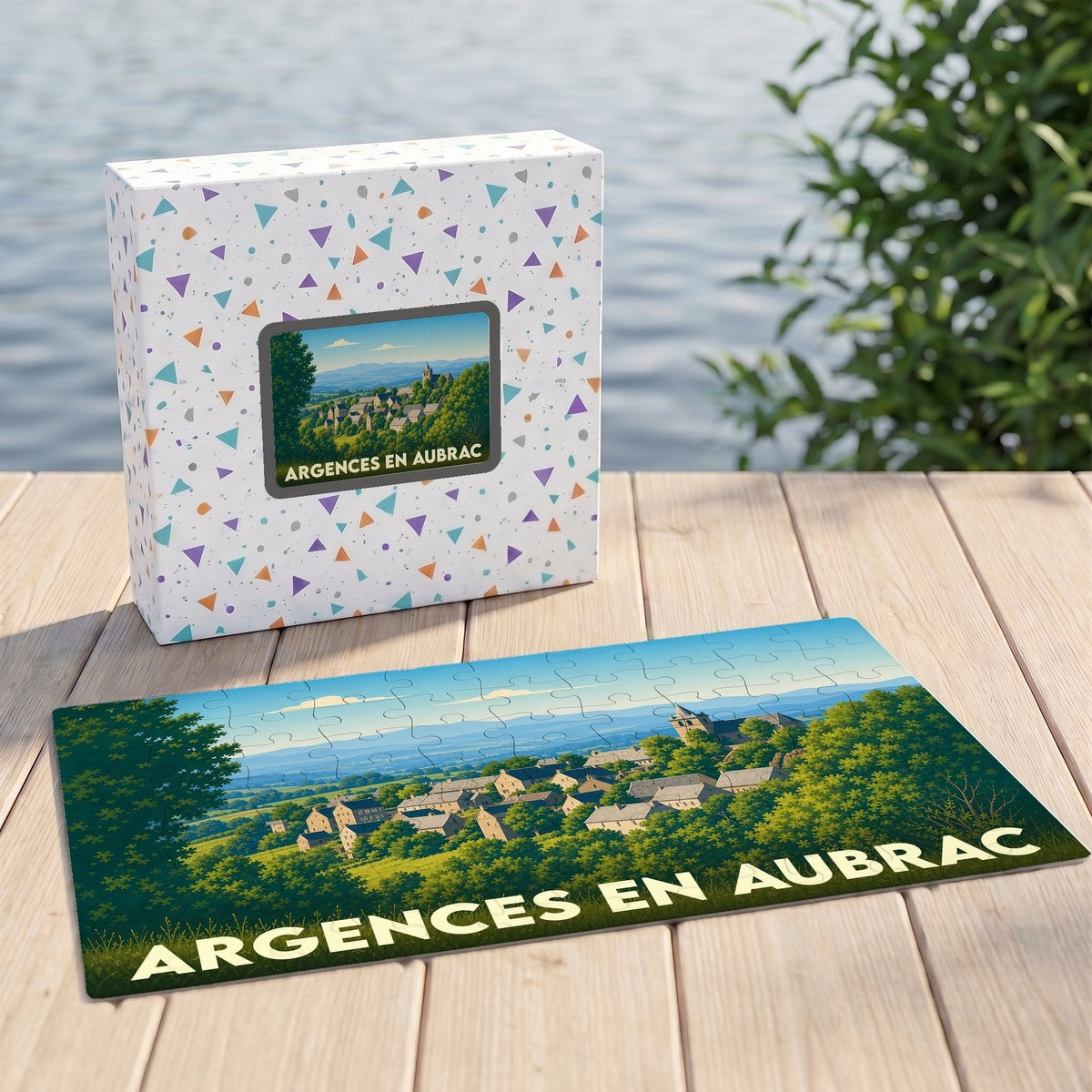 Puzzle souvenir de la ville de Argences en Aubrac illustré par un paysage de village verdoyant.