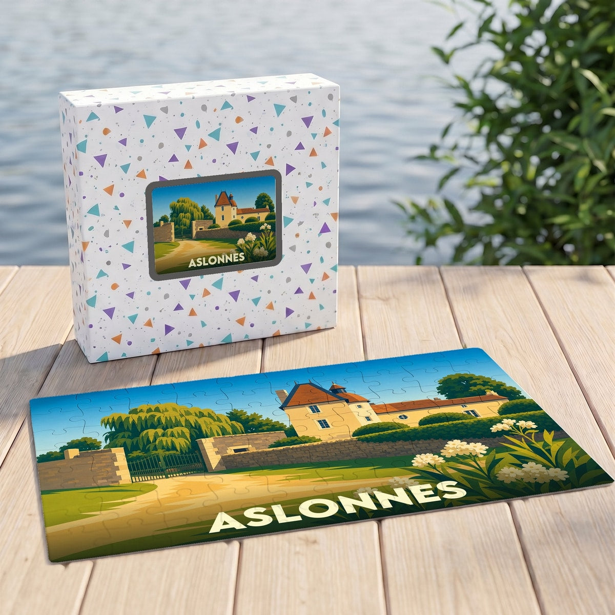 Puzzle souvenir de la ville d'Aslonnes avec son illustration de château sur un plateau en bois devant sa boîte.