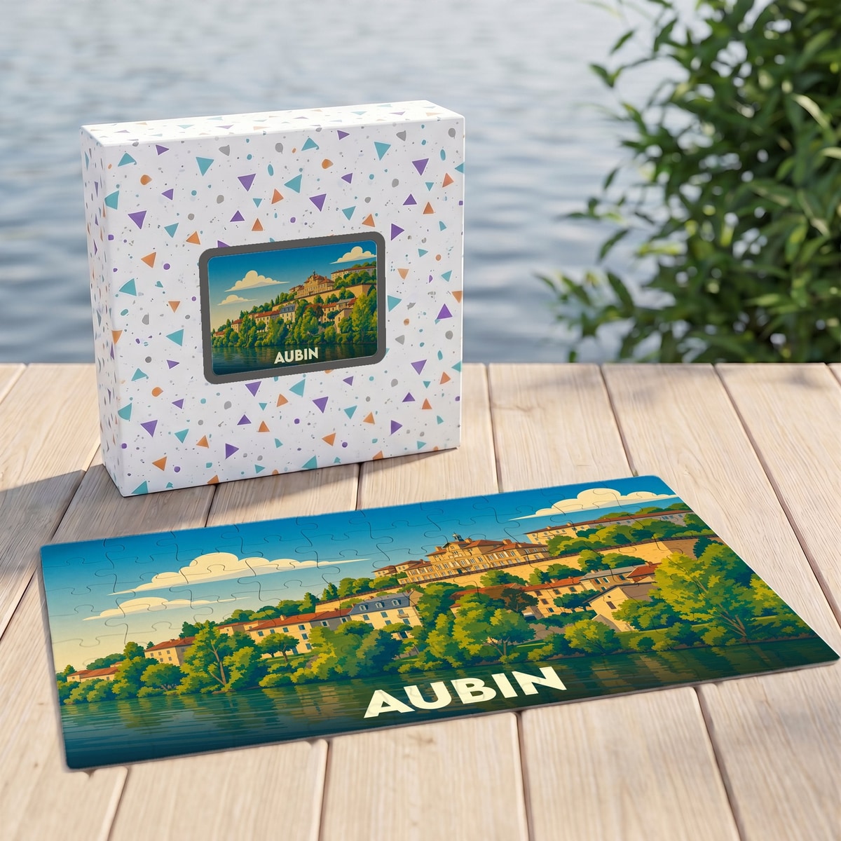 Puzzle souvenir de la ville d'Aubin avec une illustration colorée de ses paysages au bord de l'eau.