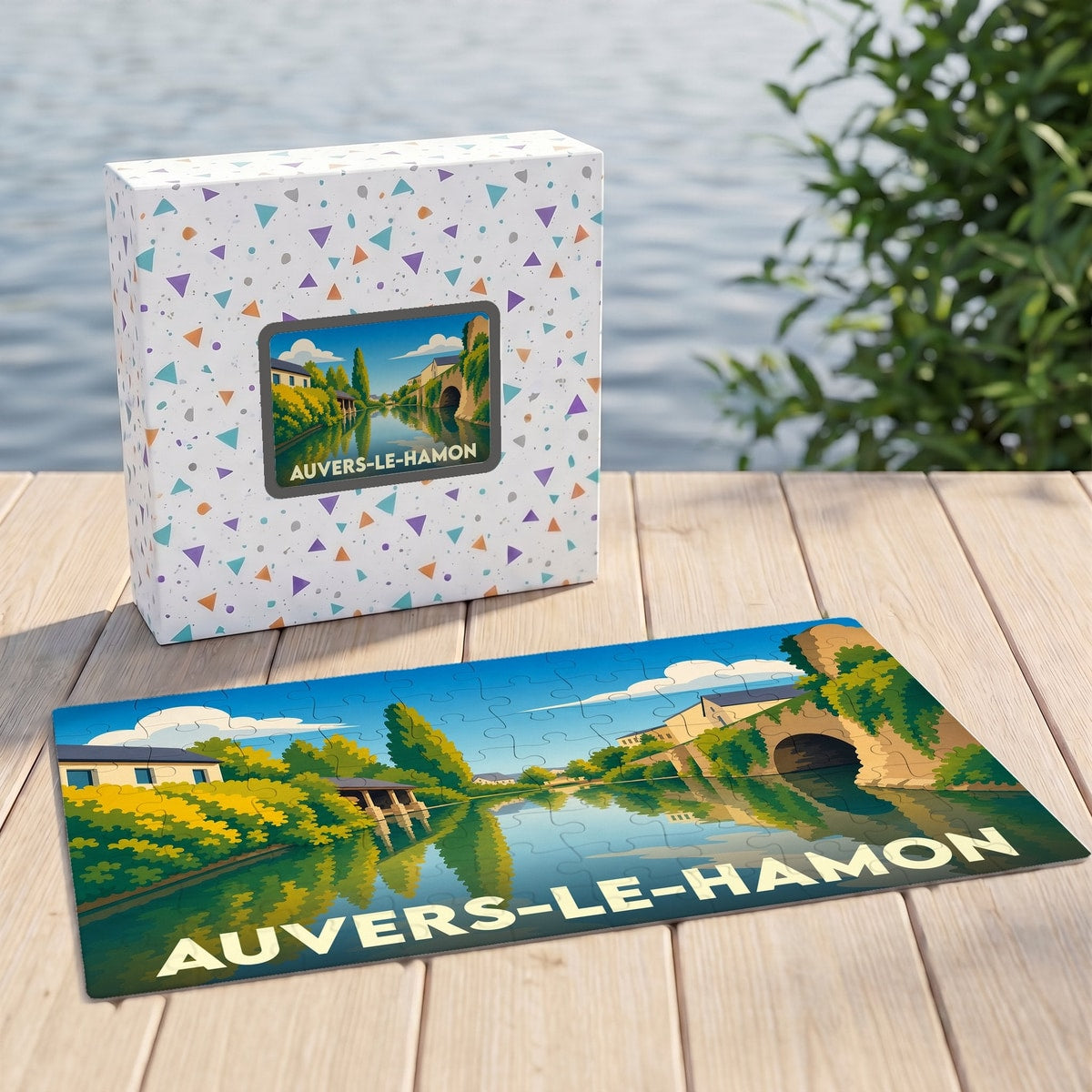 Puzzle souvenir de la ville d'Auvers-le-Hamon avec son coffret et une illustration stylisée d'un paysage fluvial.