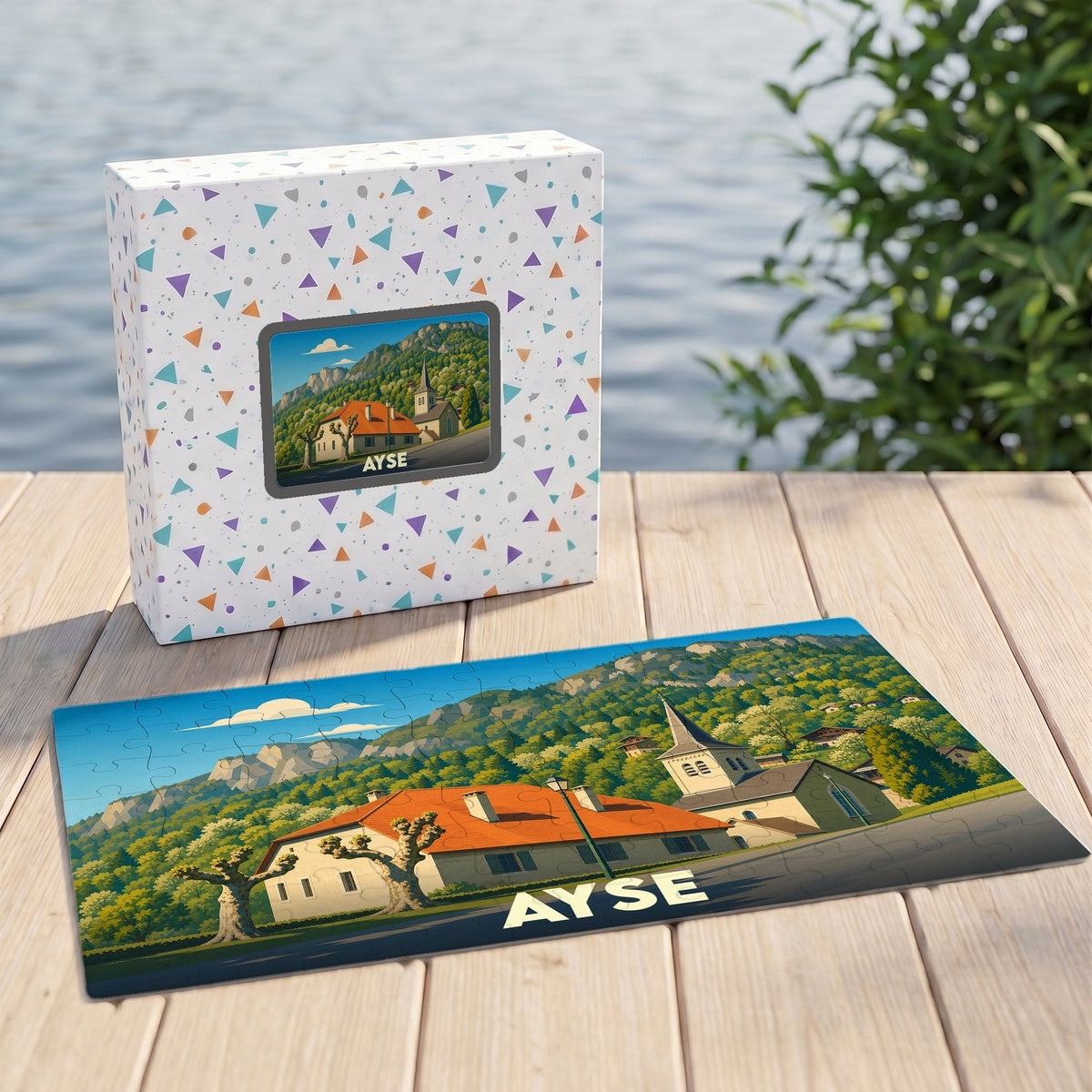 Puzzle souvenir de la ville d'Ayse illustrant un paysage de montagne et son église.