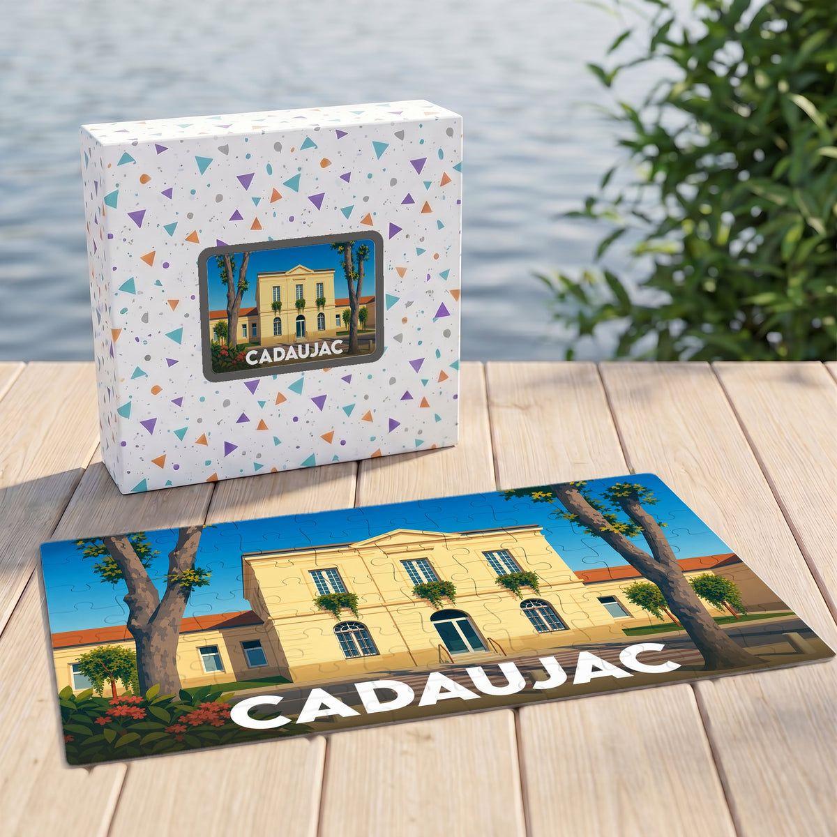 Puzzle souvenir de la ville de Cadaujac accompagné de sa boîte, illustrant une bâtisse élégante bordée d'arbres.