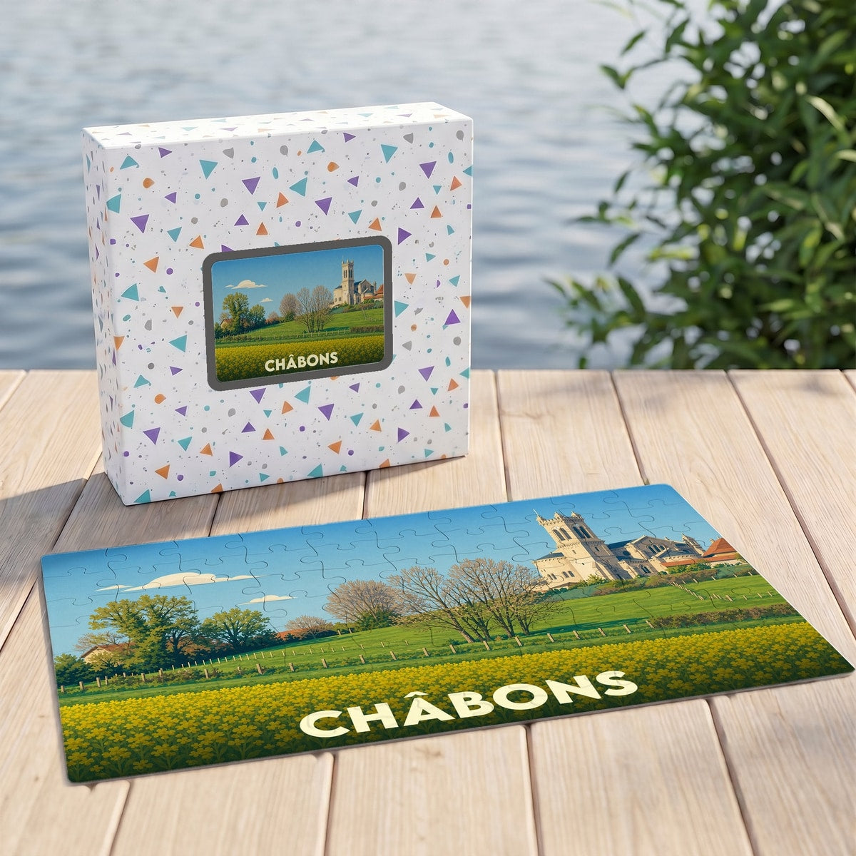 Puzzle souvenir de la ville de Châbons avec une illustration stylisée d'un paysage champêtre et de son église.