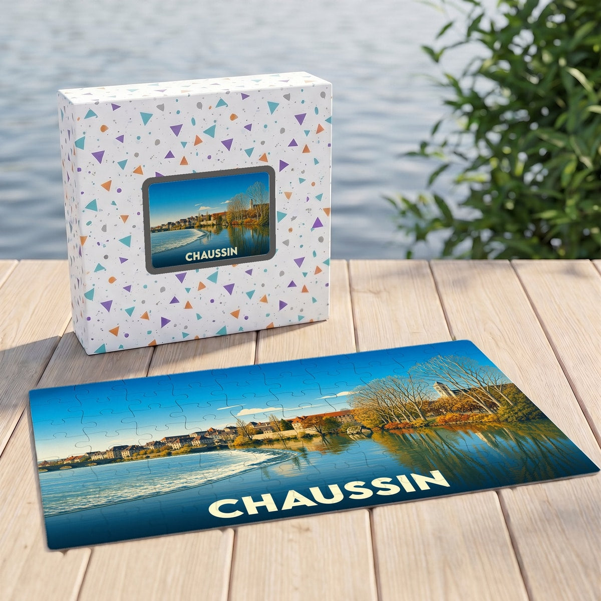 Puzzle souvenir de la ville de Chaussin avec une illustration stylisée d'un paysage au bord de l'eau.