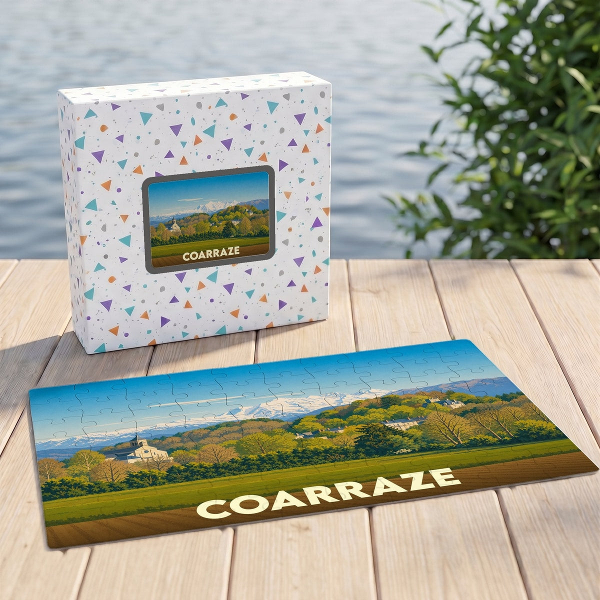 Puzzle souvenir de la ville de Coarraze avec une illustration stylisée d'un paysage de montagne.