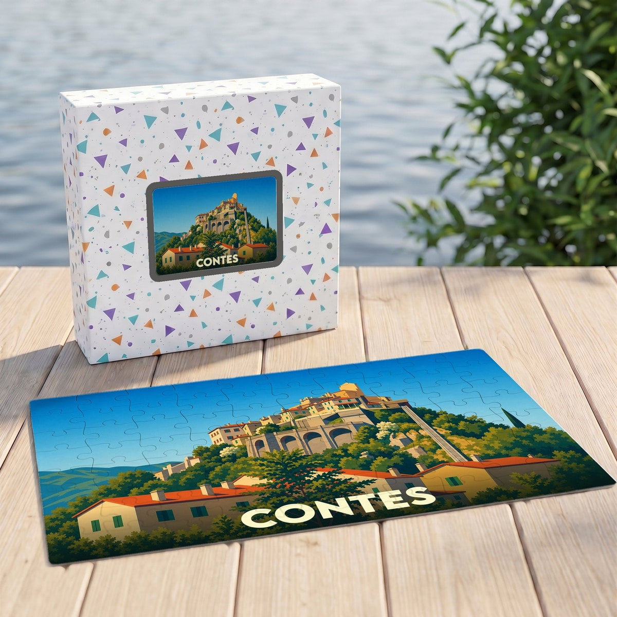 Puzzle souvenir de la ville de Contes avec une illustration stylisée d'un village perché.