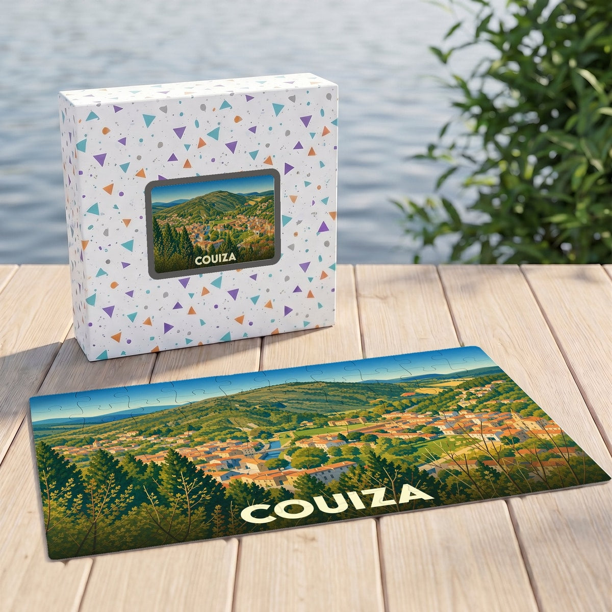 Puzzle souvenir de la ville de Couiza présentant une illustration panoramique de la commune dans sa boîte assortie.