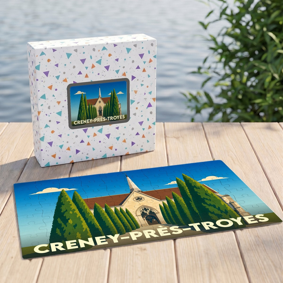 Puzzle souvenir de Creney-près-Troyes présentant une illustration stylisée de son église entourée de cyprès.