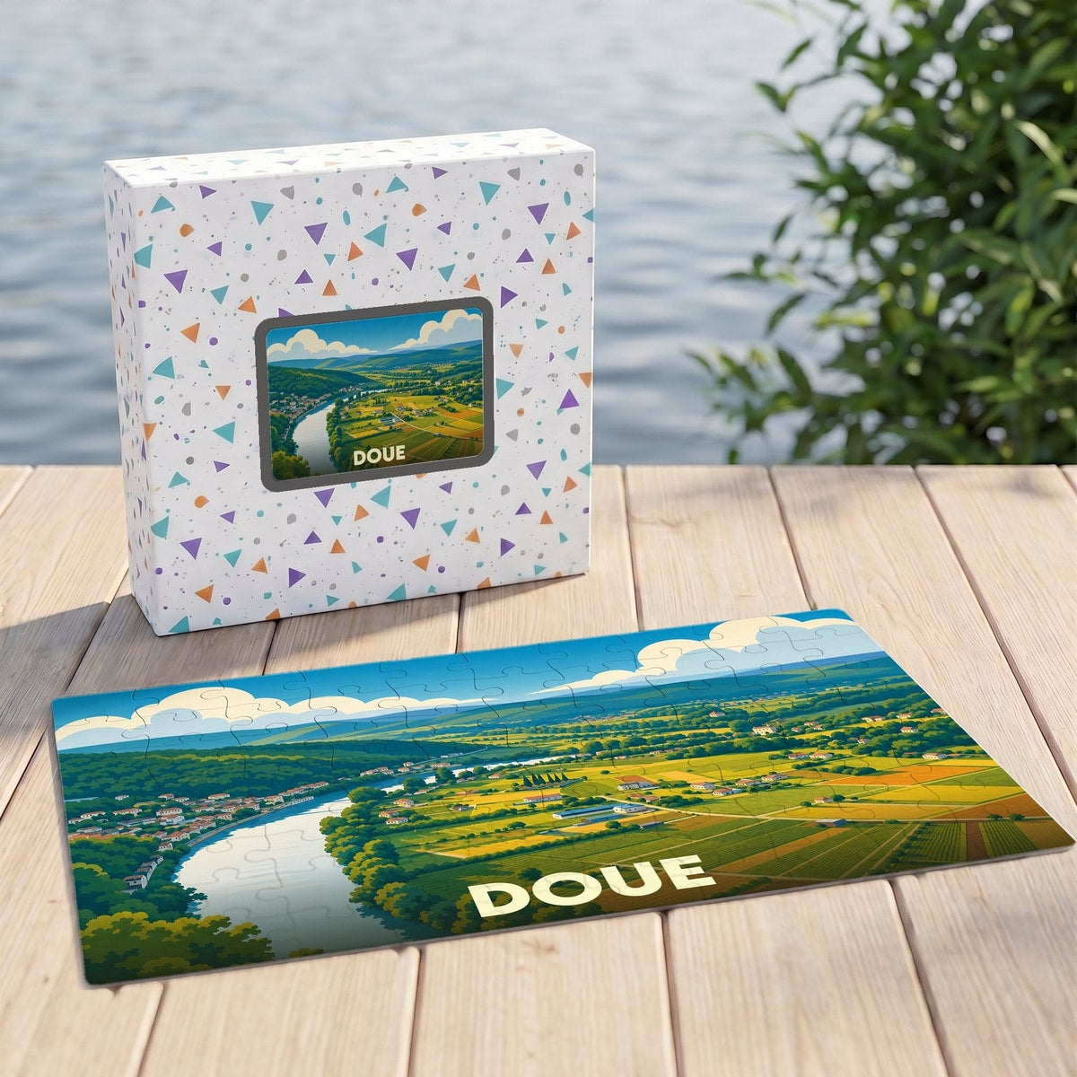Puzzle souvenir de la ville de Doue présentant une vue aérienne illustrée de la vallée et de son fleuve.