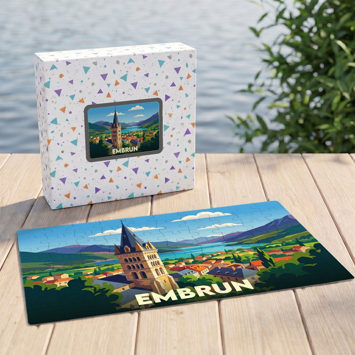 Puzzle souvenir de la ville d'Embrun avec une illustration stylisée et colorée représentant son clocher et les montagnes environnantes.