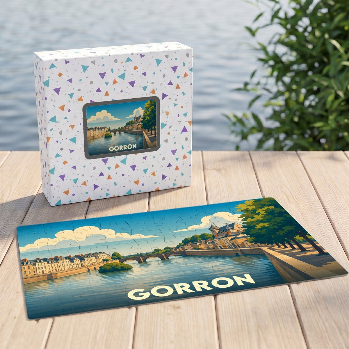 Puzzle souvenir de la ville de Gorron avec une illustration stylisée des bords de l'eau et son emballage assorti.