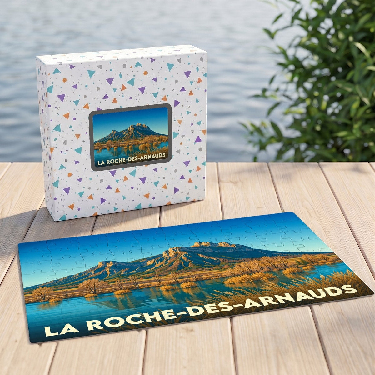 Puzzle souvenir de la ville de La Roche-des-Arnauds représentant un paysage de montagne au bord de l'eau.