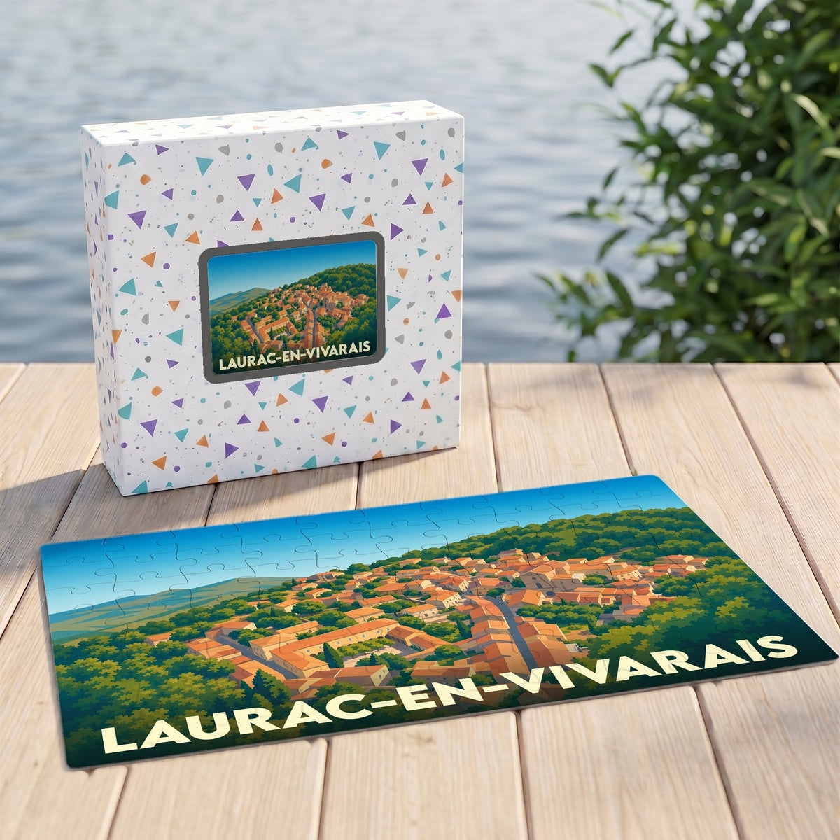 Puzzle souvenir de la ville de Laurac-en-Vivarais avec son boîtier assorti présentant une illustration stylisée du village.
