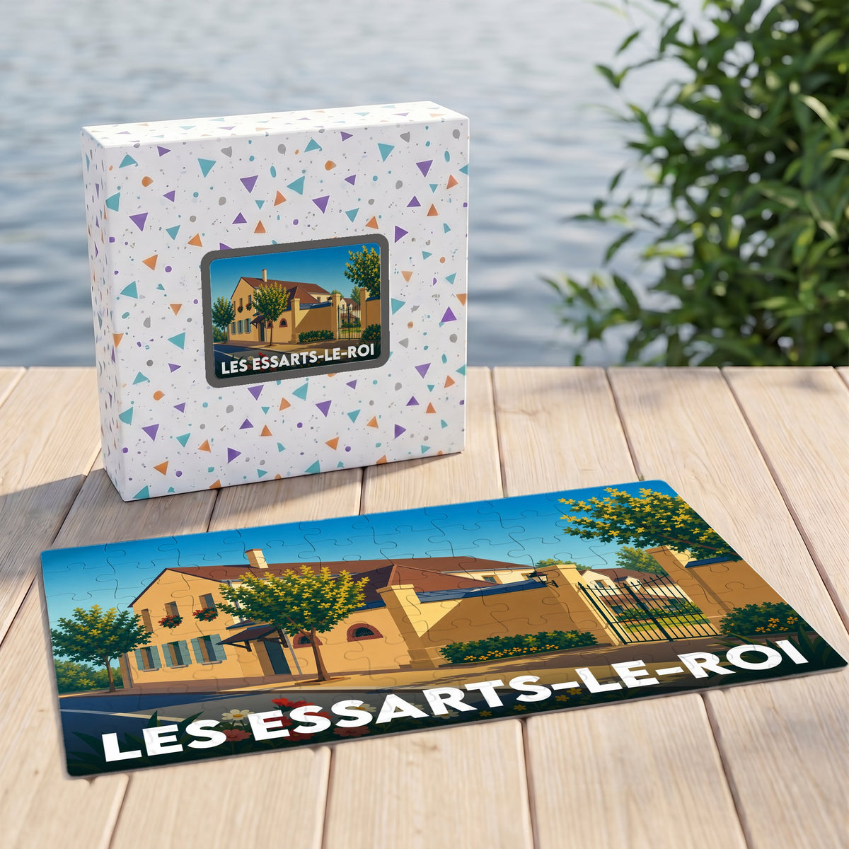 Puzzle souvenir de la ville de Les Essarts-le-Roi avec son coffret, présentant une illustration stylisée d'un paysage urbain.