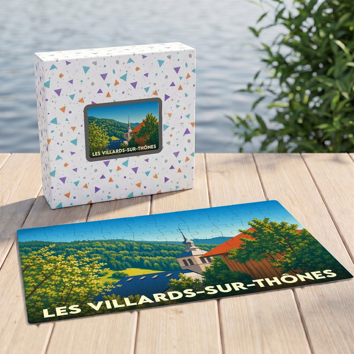 Puzzle souvenir de la ville de Les Villards-sur-Thônes présentant une illustration paysagère stylisée et sa boîte assortie.