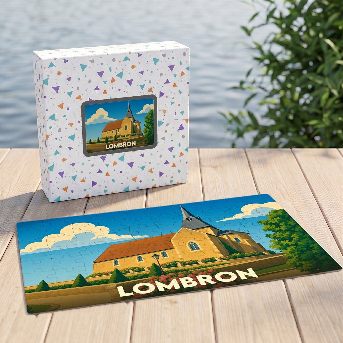 Puzzle souvenir de la ville de Lombron avec une illustration stylisée de son église sur la boîte et le plateau.
