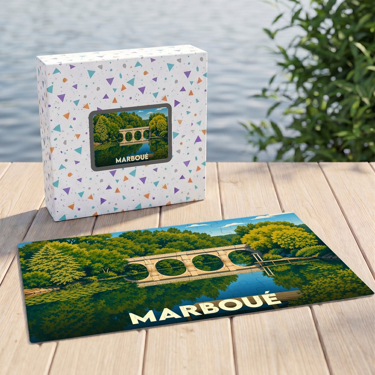 Puzzle souvenir de la ville de Marboué avec une illustration stylisée d'un pont de pierre au bord de l'eau.