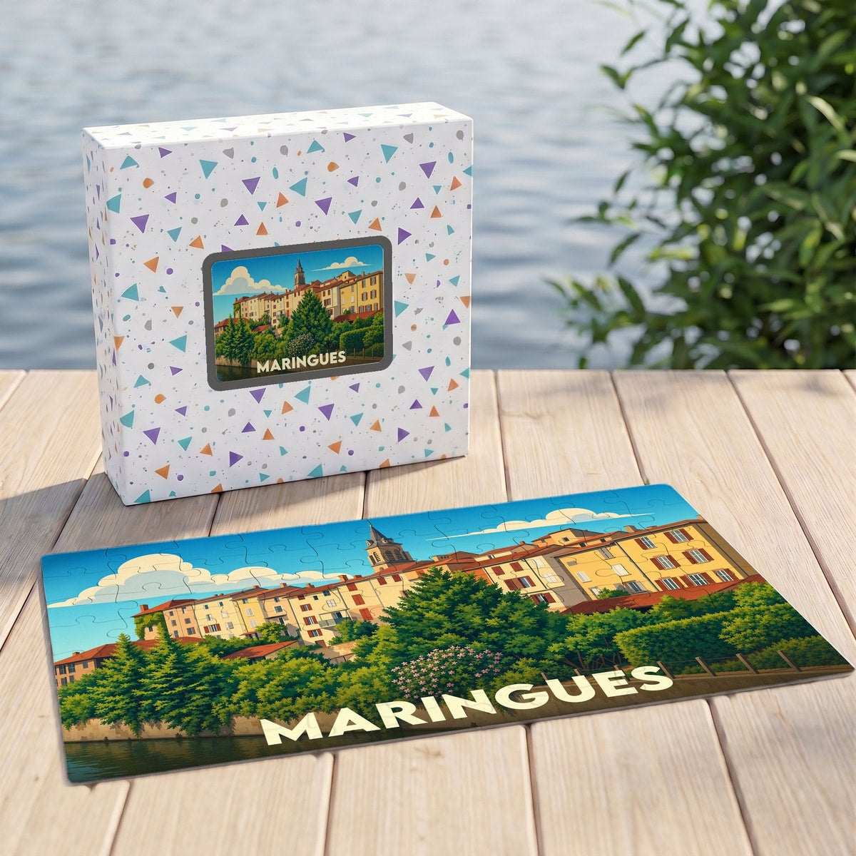 Puzzle souvenir de la ville de Maringues avec une illustration stylisée de ses bâtiments colorés en bord de rivière.