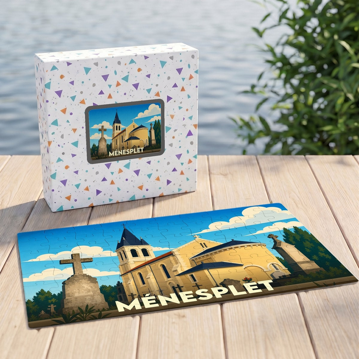 Puzzle souvenir de la ville de Ménesplet avec une illustration stylisée d'une église et de son cimetière.