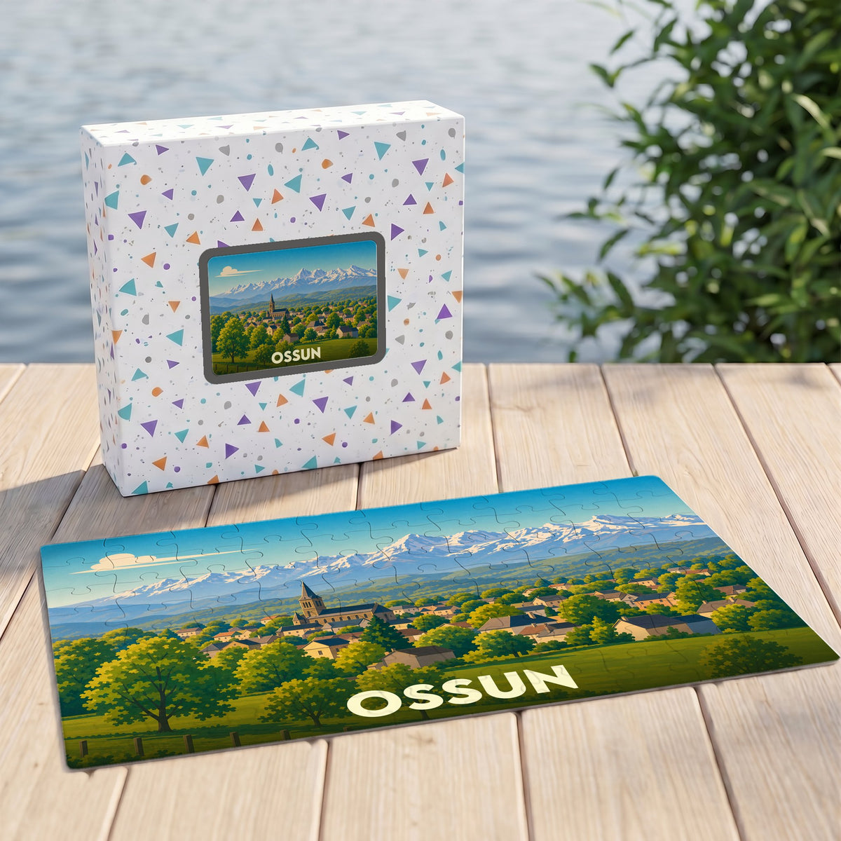 Puzzle souvenir de la ville d'Ossun illustrant un paysage de village devant une chaîne de montagnes enneigées.