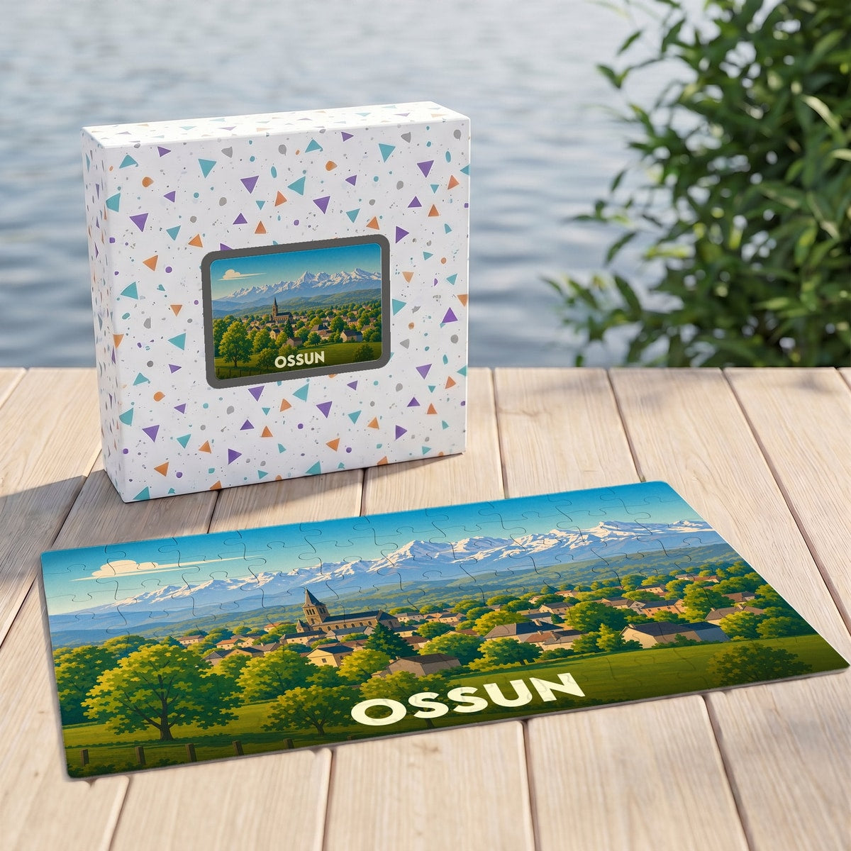 Puzzle souvenir de la ville d'Ossun illustrant un paysage de village devant une chaîne de montagnes enneigées.
