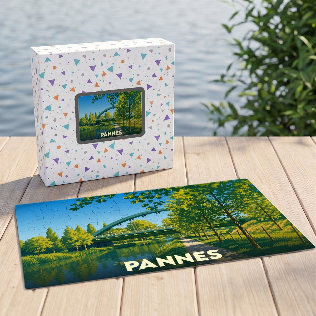 Puzzle souvenir de la ville de Pannes représentant un paysage arboré avec un pont traversant un canal.
